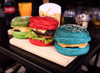 Três hambúrgueres coloridos (vermelho, azul e verde) sobre mesa de hamburgueria.