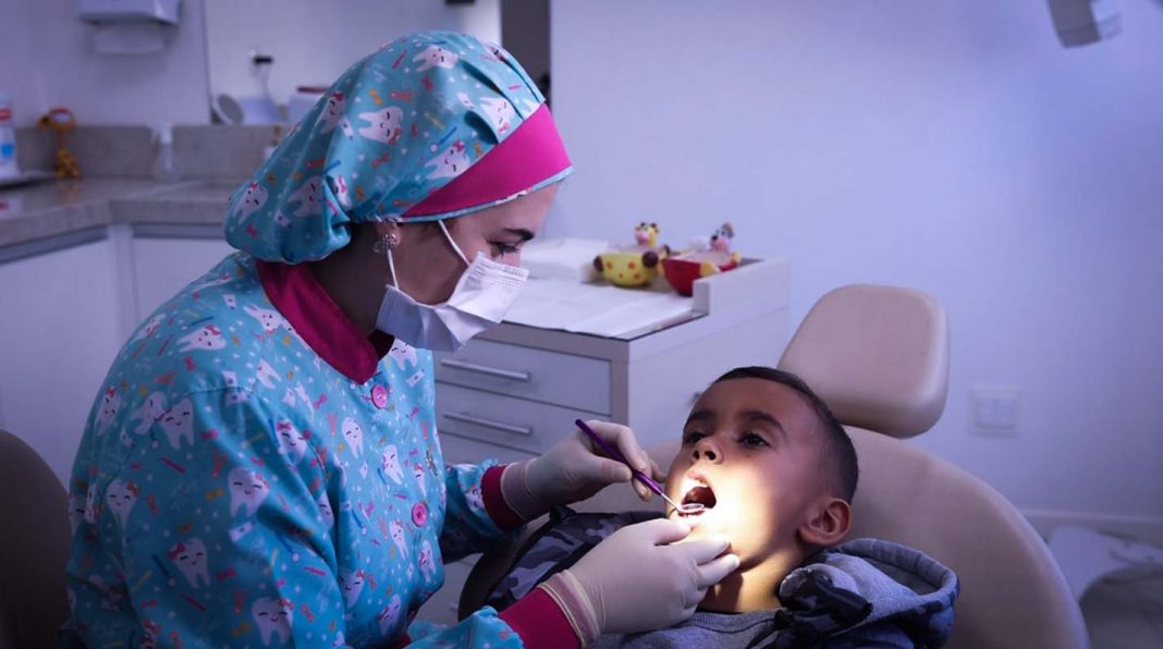 Dentista da Espaço Odonto avaliando saúde bucal de criança