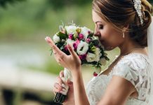 Noiva vestida para casamento cheirando um buquê de flores