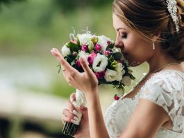Noiva vestida para casamento cheirando um buquê de flores
